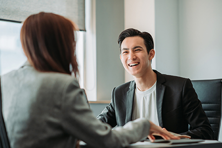 two people in a meeting, laughing