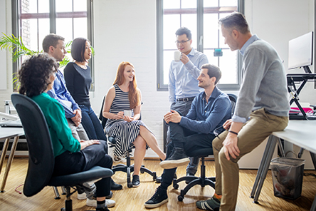 seven people meeting and talking in a work area